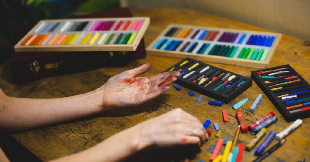 Colorful pastels and artist's hands in a creative indoor studio setting.