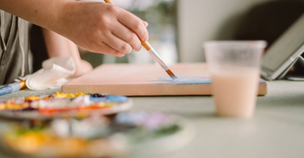 Artist applying blue paint on canvas in a sunlit home studio. Creative workspace ambiance.